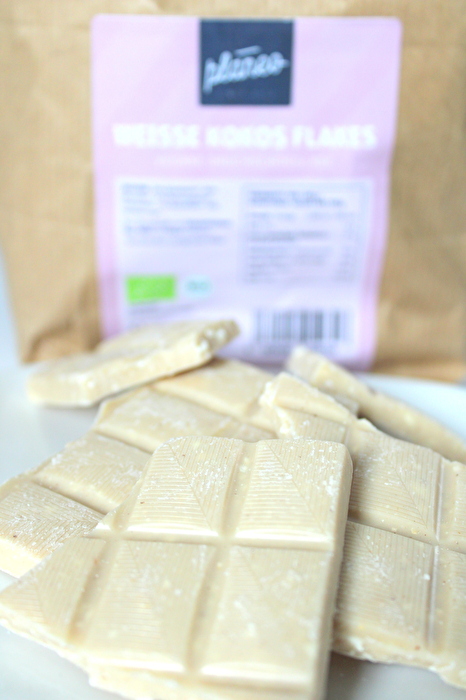 Die Bruchschokolade Weisse Kokos Flakes von planeo ist eine unvergleichlich zarte, weiße Schokolade aus rein pflanzlichen Zutaten.