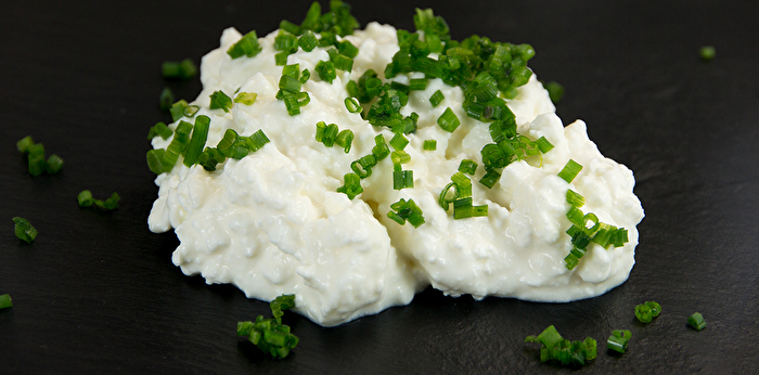 Die cremefarbenen Stückchen mit feinen Kräutern erinnern optisch und in ihrer Konsistenz an klassischen Hüttenkäse.